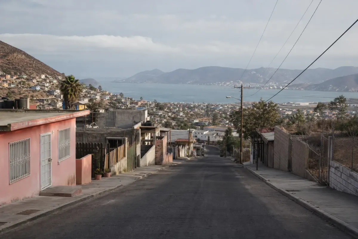 An Ensenada street descends toward the bay between coastal hills.